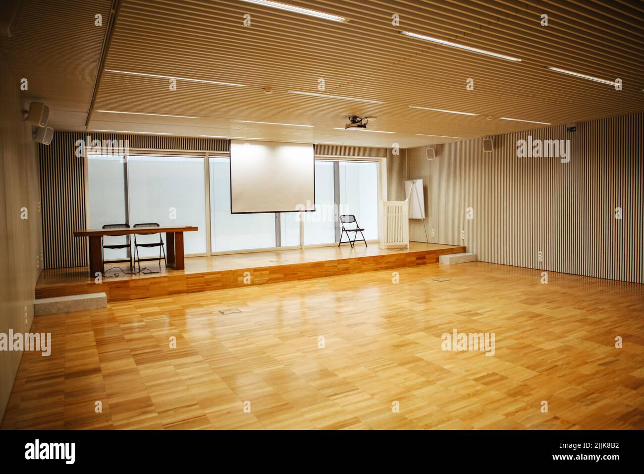 Una sala de conferencias iluminada con una pizarra blanca para presentaciones y espacio para sillas Foto de stock
