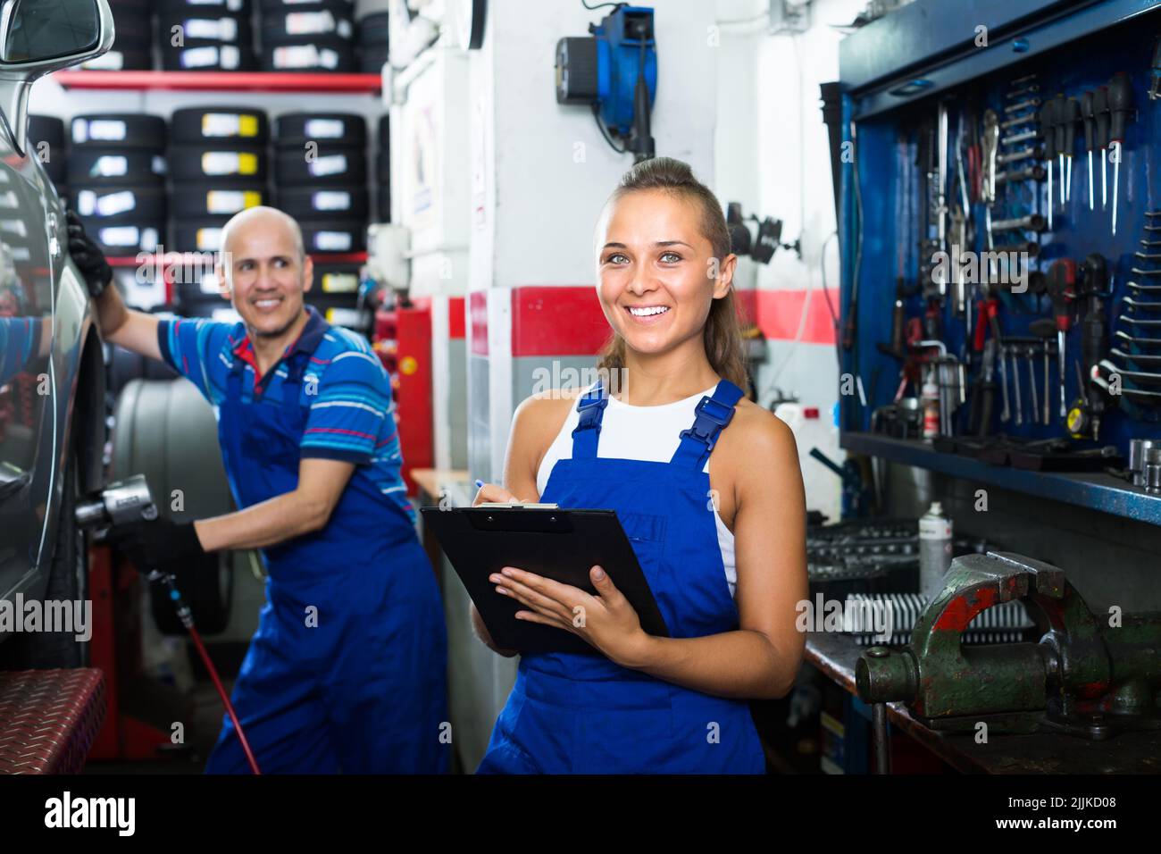chica en ropa de trabajo en taller mecánico de automóviles Fotografía de  stock - Alamy