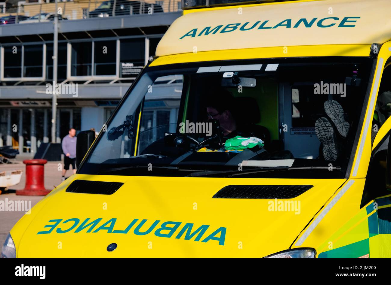 Paramédicos del NHS en pausa para el almuerzo con ambulancia. En uniforme y en espera en caso de emergencia. Ambulancia de alta visibilidad. Foto de stock