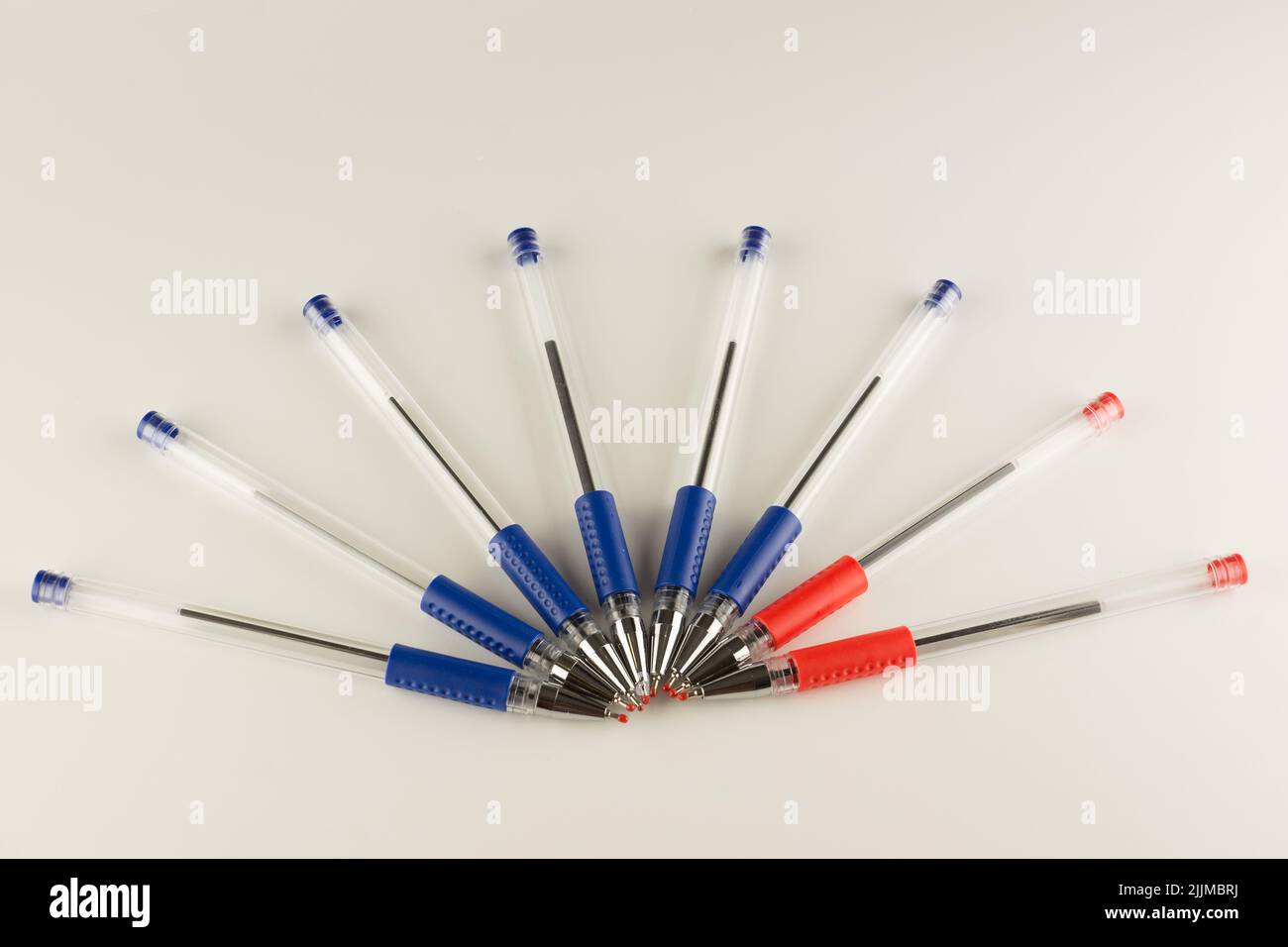 juego de bolígrafos azules alineados con un arco sobre un fondo blanco Foto de stock