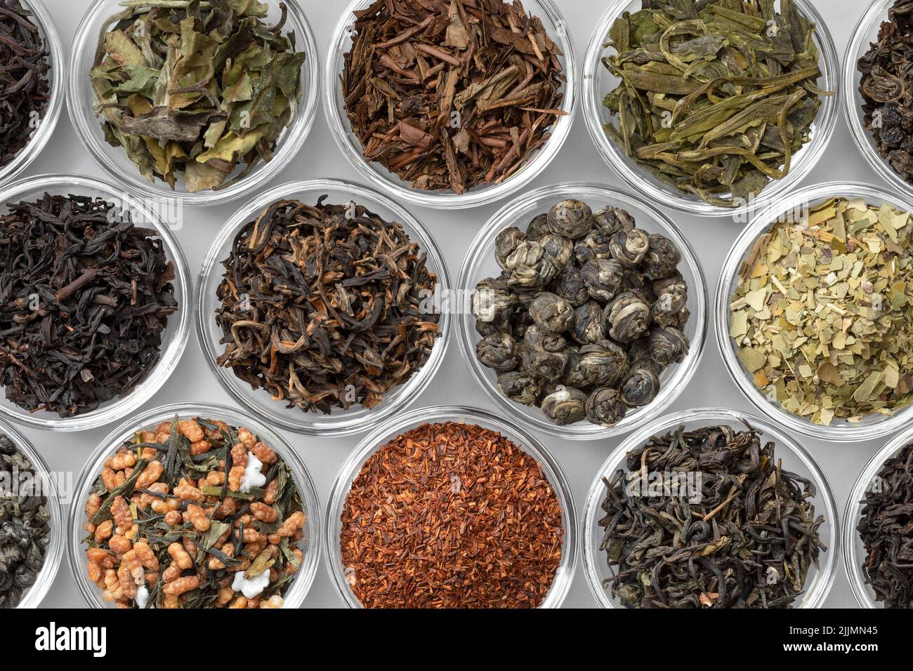 Cuencos de Glas con una variedad de diferentes hojas de té seco de China, India, Japón y Sudáfrica primer plano de cuadro completo Foto de stock