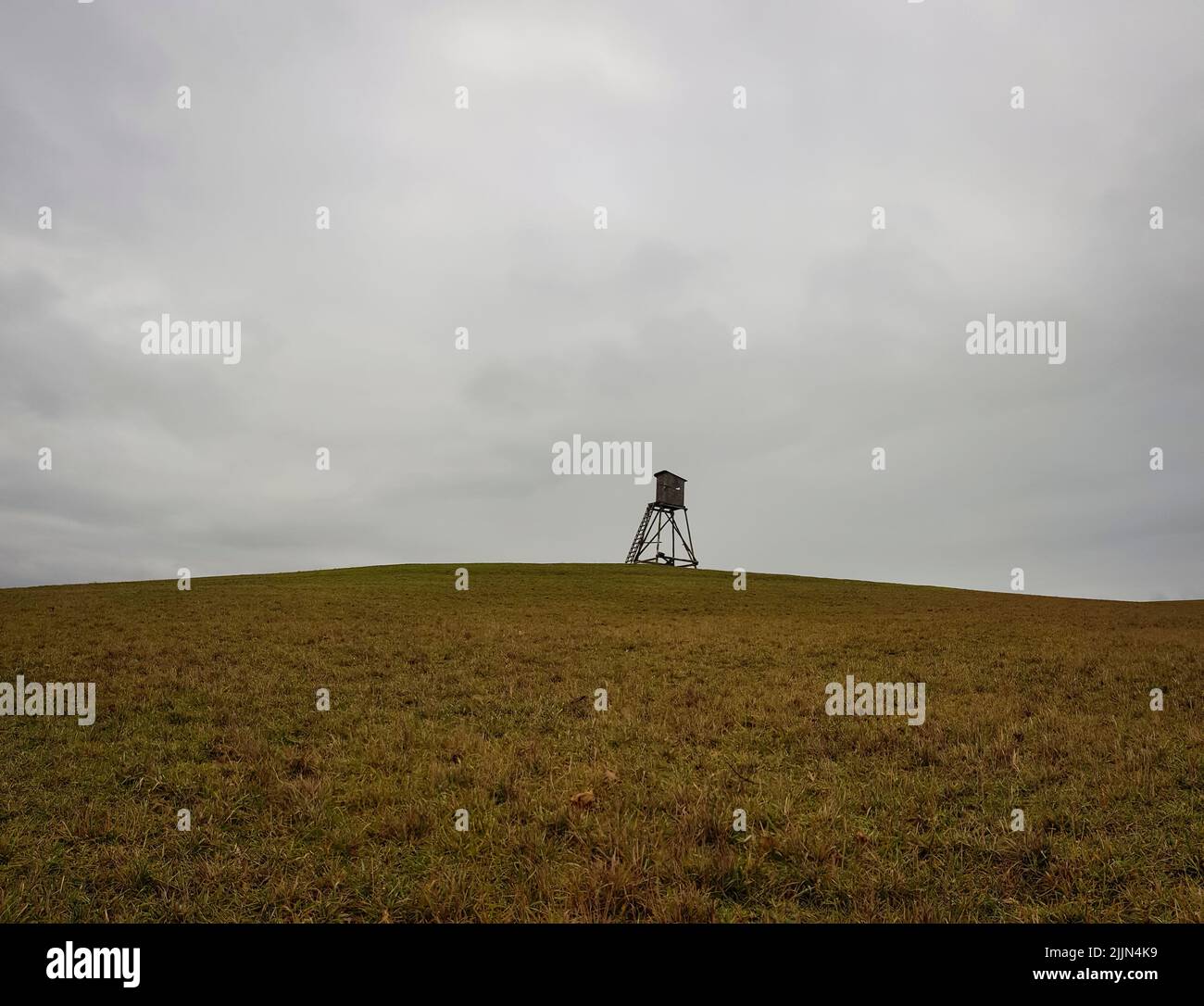 Vista panorámica de un mirador de madera en un campo abierto en un día nublado Foto de stock