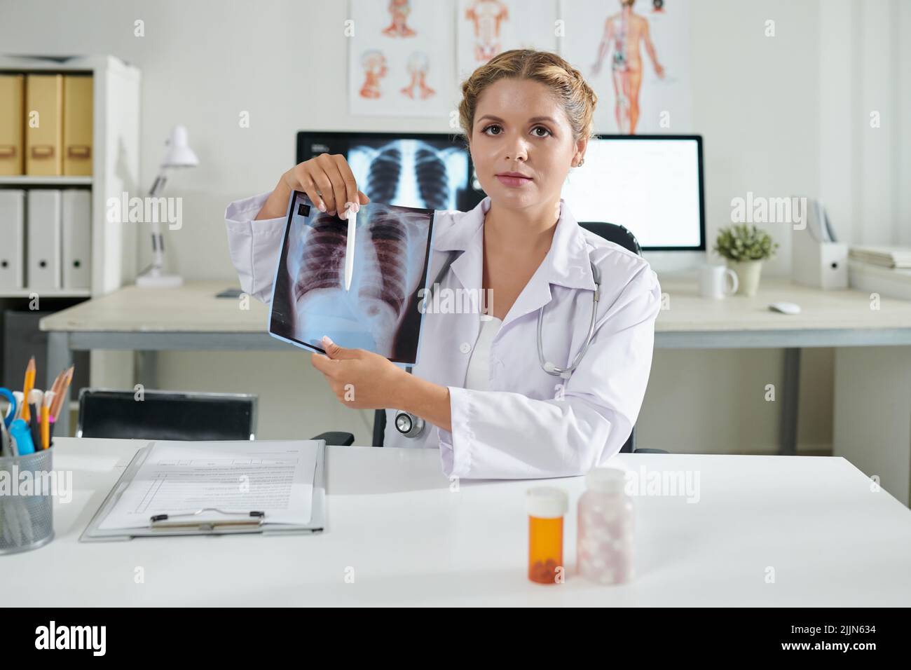 Retrato de un médico de cabecera joven y serio que señala en la