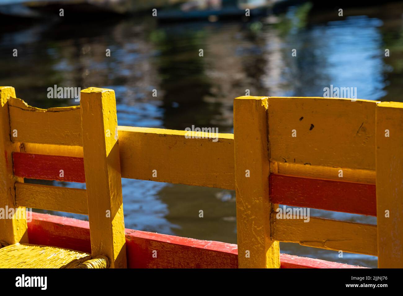 Las distintivas sillas amarillas de los barcos trajinera que recorren los canales de Xochimilco en la Ciudad de México Foto de stock
