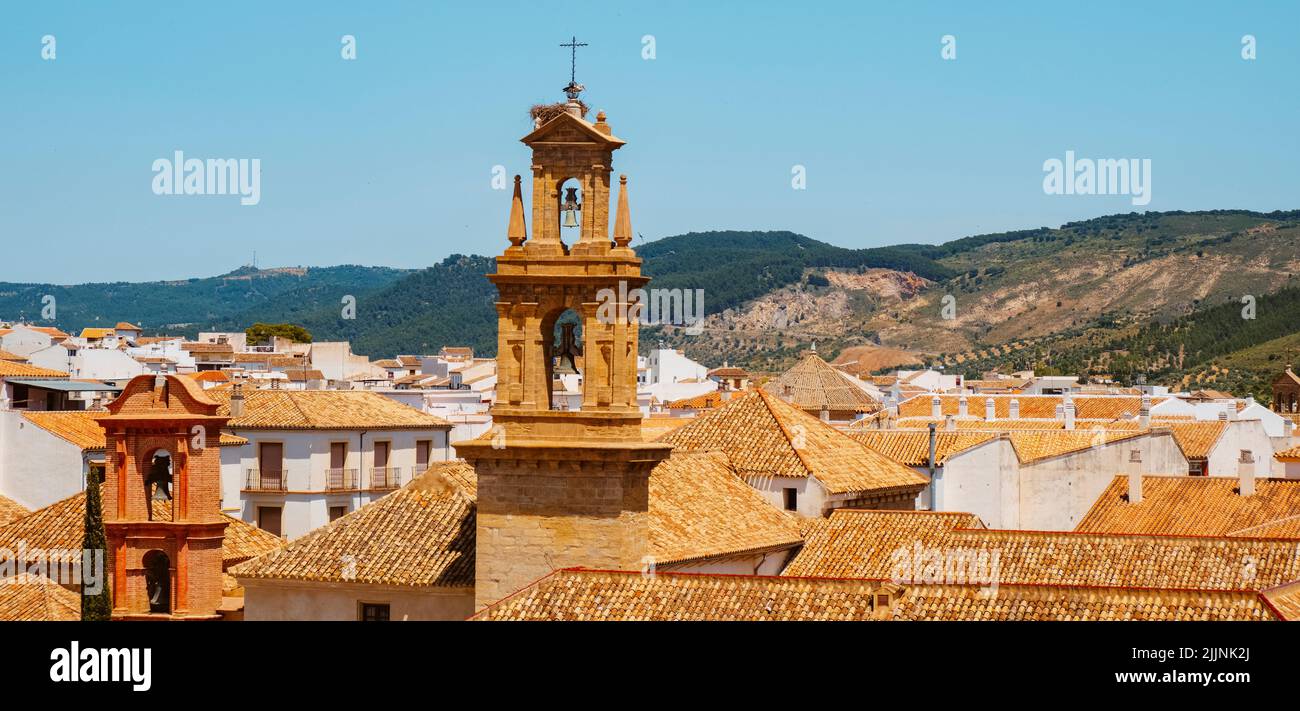 Una vista de los tejados del casco antiguo de Antequera, en la provincia de Málaga, España, destacando el campanario de la iglesia de San Zoilo en un soleado spri Foto de stock