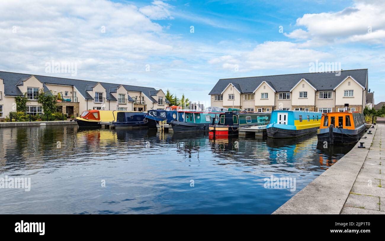 Ratho, Scotland, Reino Unido, 27th de julio de 2022. Clima en el Reino Unido: Tarde soleada en el Canal de la Unión. Coloridos barcos estrechos en Ratho Marina Basin Foto de stock