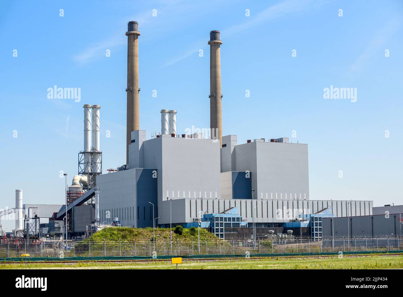 Vista de una central eléctrica de carbón bajo el cielo azul en un soleado día de verano Foto de stock