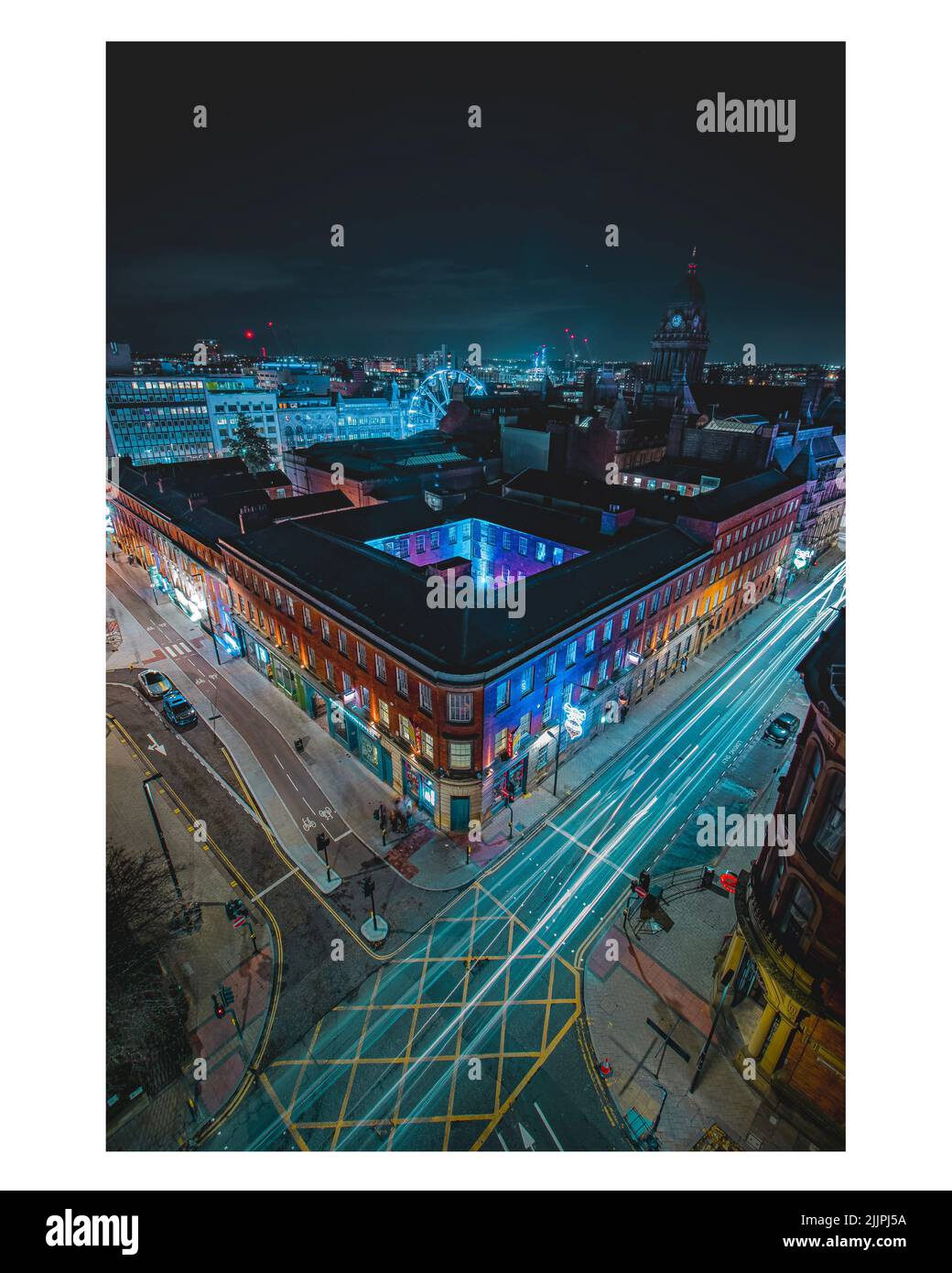 Una imagen vertical del paisaje urbano de larga exposición con edificios y luces durante la noche Foto de stock