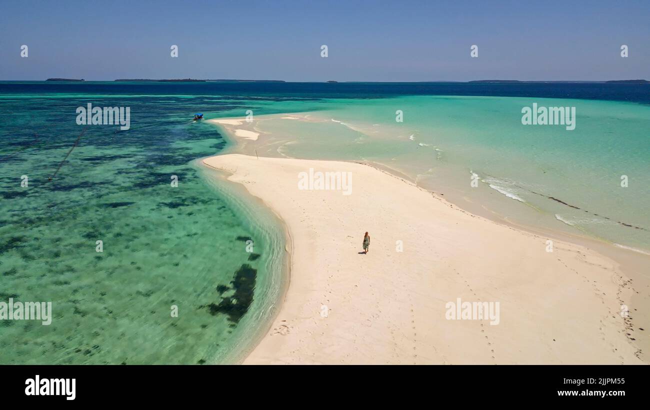 Vista aérea de una mujer caminando por la playa de Ngurtafur, islas Kei, provincia de Maluku, Indonesia Foto de stock