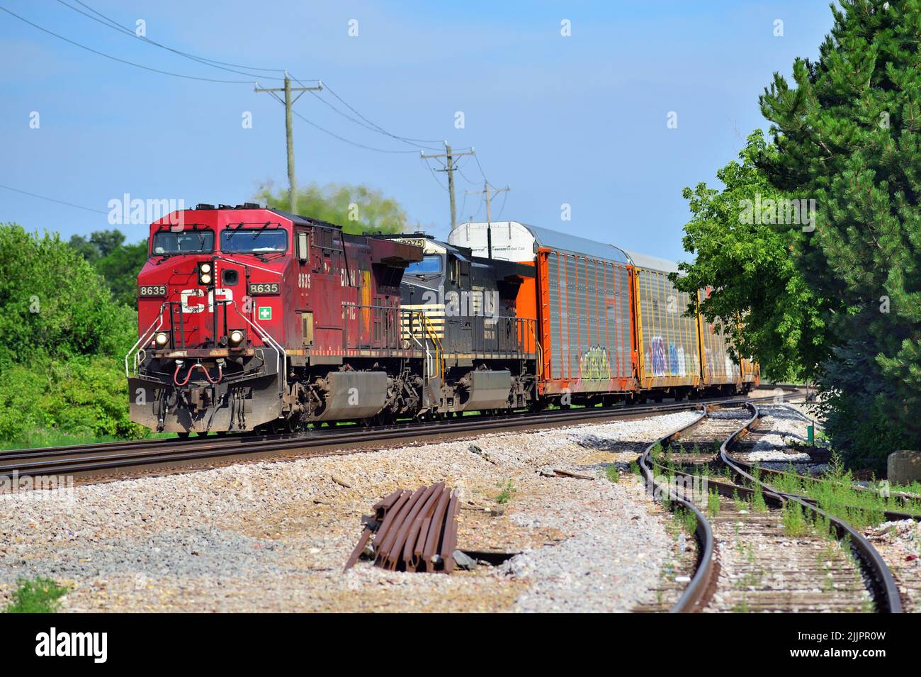 Bartlett, Illinois, EE.UU. Un par de locomotoras, incluyendo una unidad fuera de carretera Norfolk Southern, impulsan un tren de carga a través del noreste de Illinois. Foto de stock
