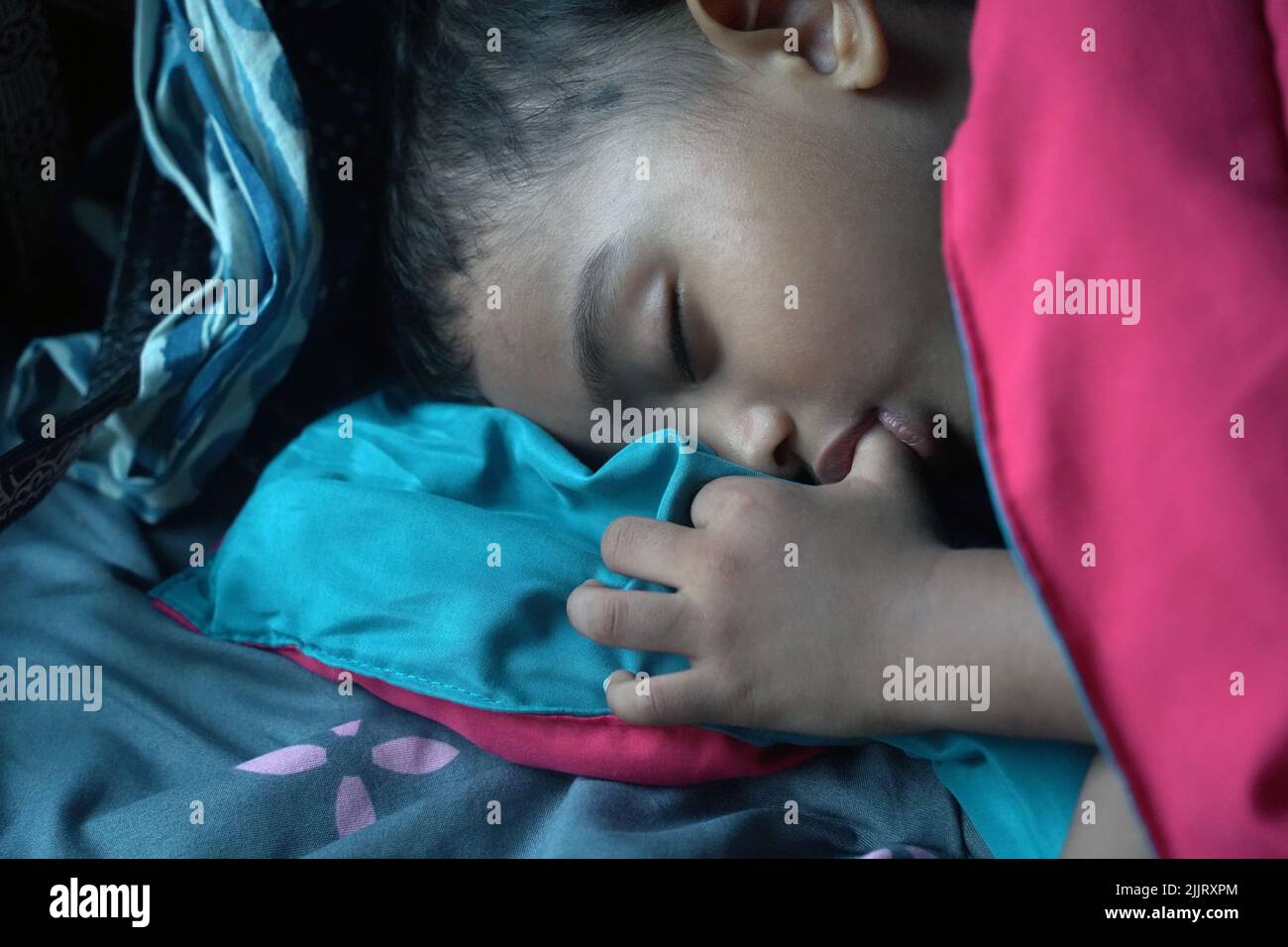Un primer plano retrato de una chica del sur de Asia chupando su pulgar mientras duerme Foto de stock