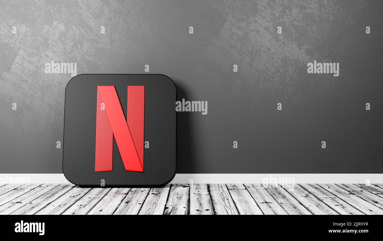 Logotipo de Netflix en el suelo de madera contra la pared Foto de stock