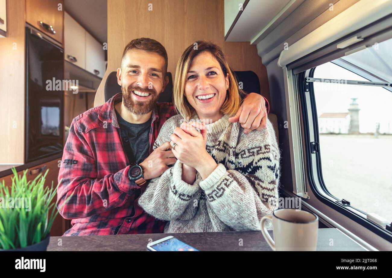 Una pareja feliz hablando mirando la cámara en una videollamada desde su furgoneta Foto de stock