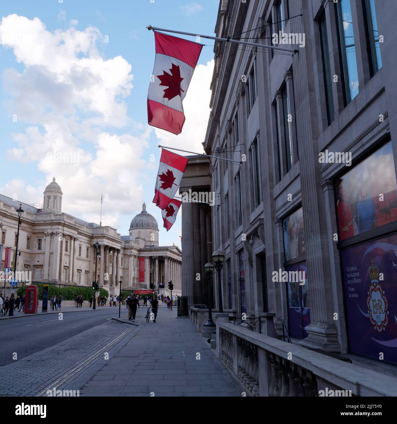 Londres, Gran Londres, Inglaterra, Junio 30 2022: Banderas canadienses fuera de la Embajada Canadiense con la Galería Nacional al fondo. Foto de stock