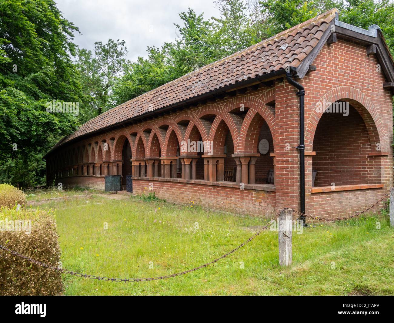 Claustros de ladrillo rojo en los terrenos de la capilla Watts, Compton, Surrey, Reino Unido Foto de stock