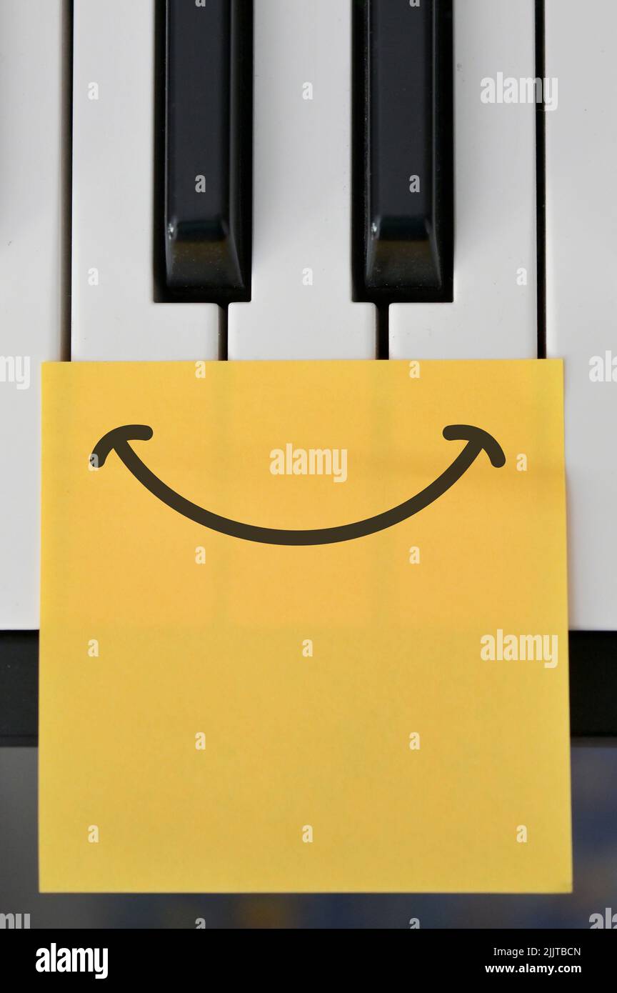 Toma abstracta del teclado de piano y Dibuja una nota de sonrisa feliz Foto de stock