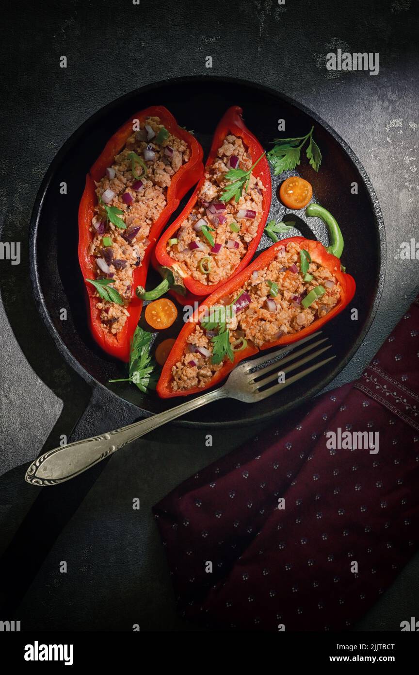 Campana roja rellena con carne picada y verduras en la sartén Foto de stock