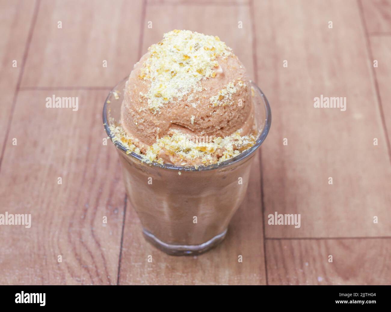 Una porción de delicioso helado de café sobre una superficie de madera Foto de stock