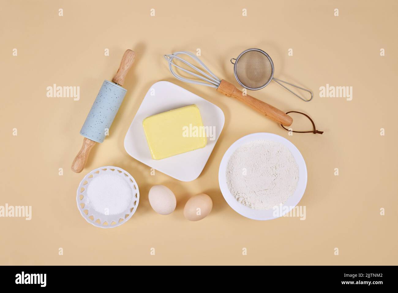 Ingredientes para masa de pasteles y herramientas para hornear sobre fondo beige Foto de stock
