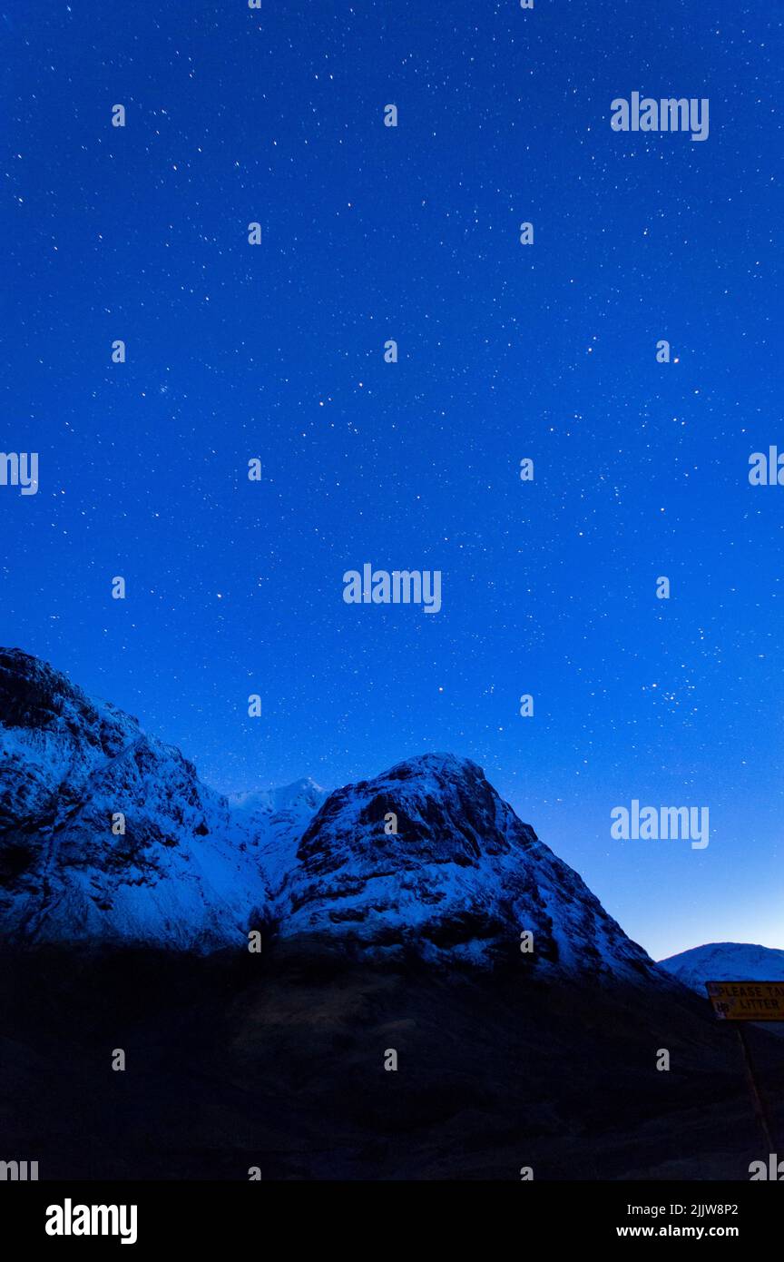 Una hermosa vista de las tierras altas escocesas contra un cielo estrellado por la noche visto desde el mirador Three Sisters Foto de stock