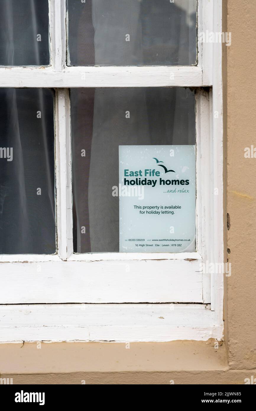 Un cartel en la ventana de una cabaña en St Monans en el East Neuk de Fife dice: Esta propiedad está disponible para alquiler vacacional. Foto de stock