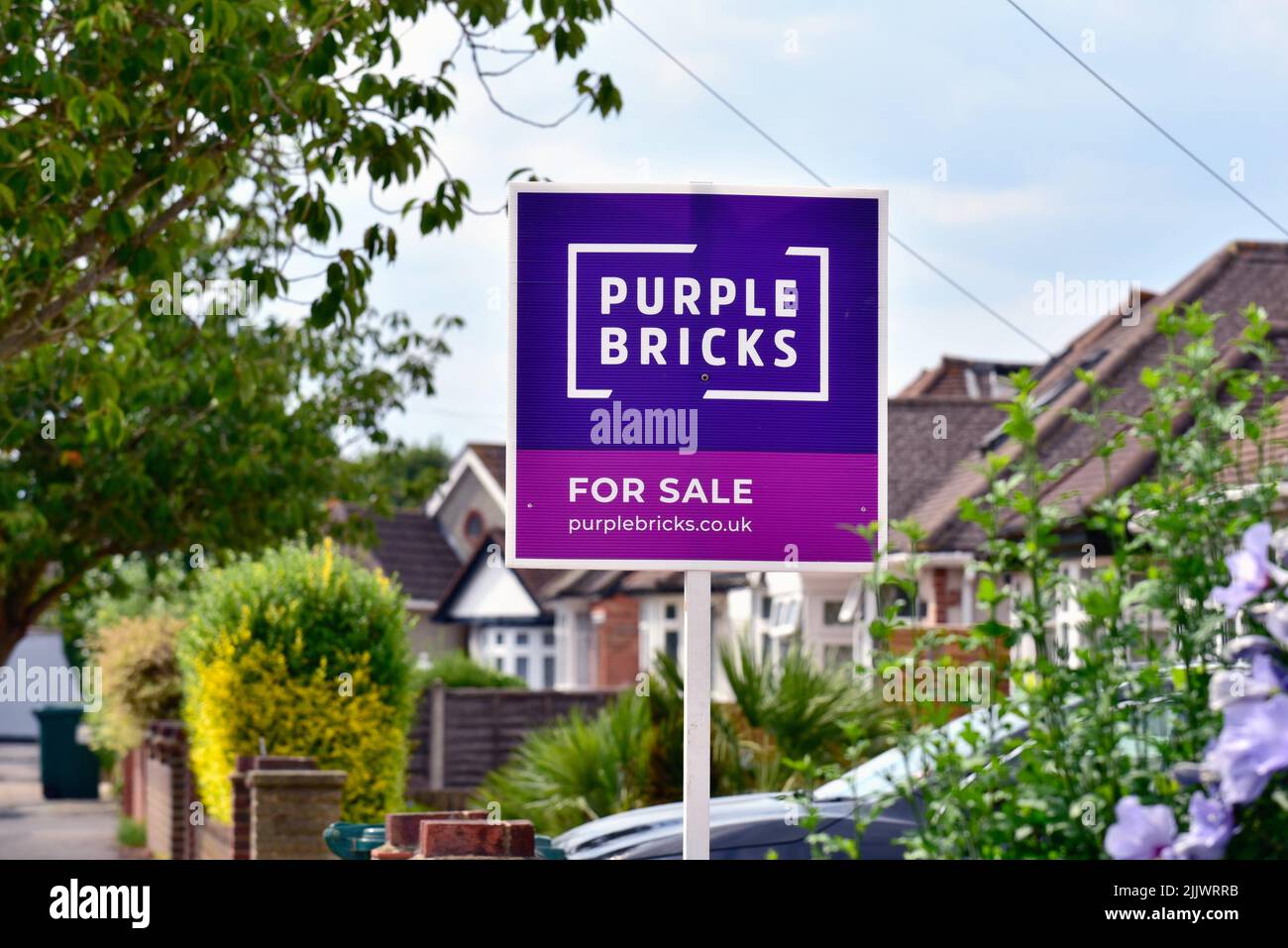 A 'Purple Bricks' agentes inmobiliarios en línea firman fuera de una casa suburbana en Shepperton Surrey Reino Unido Foto de stock