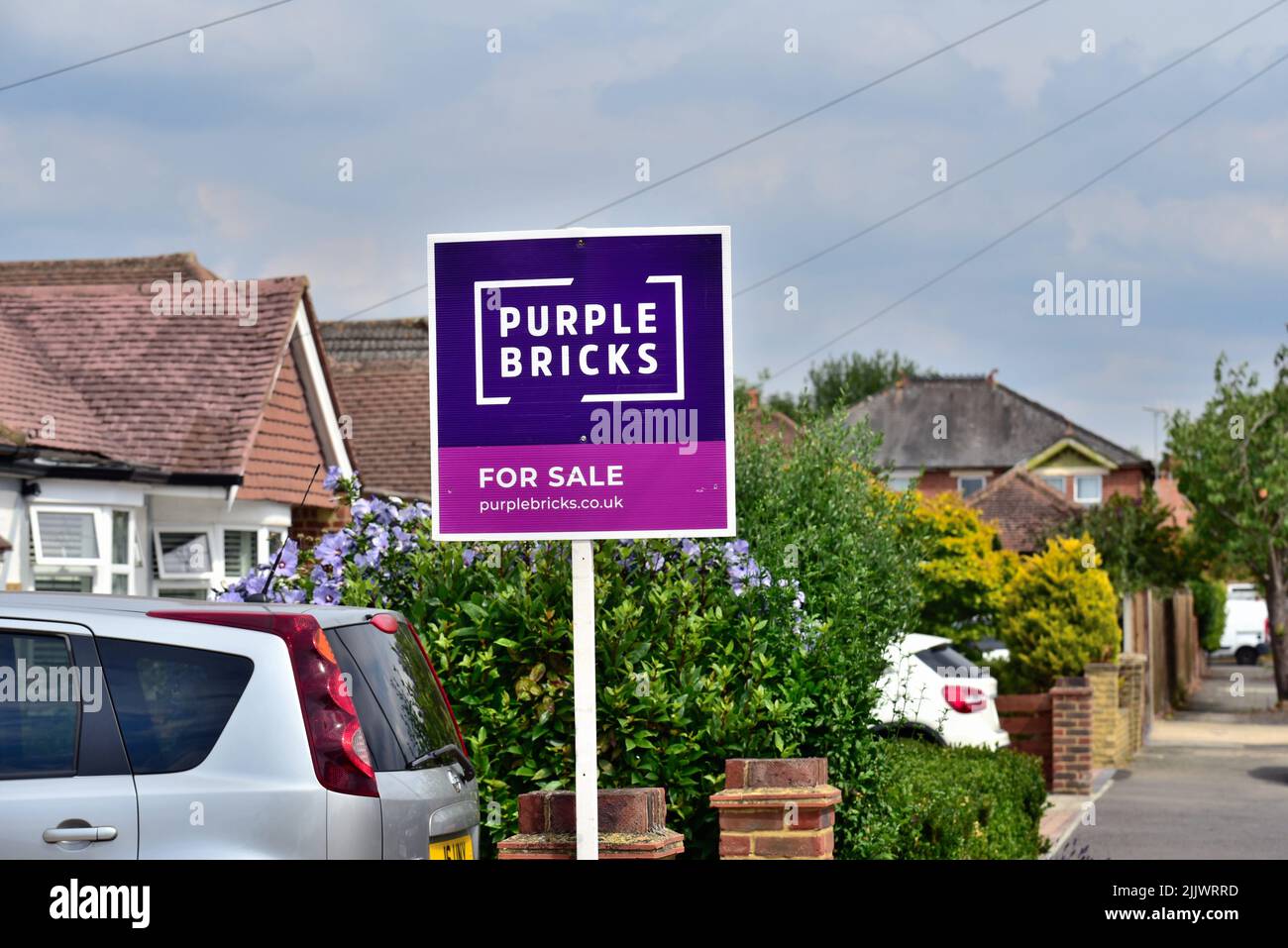 A 'Purple Bricks' agentes inmobiliarios en línea firman fuera de una casa suburbana en Shepperton Surrey Reino Unido Foto de stock