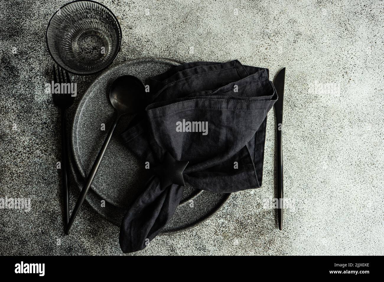 Vajilla negra minimalista sobre mesa de hormigón oscuro Fotografía de stock  - Alamy