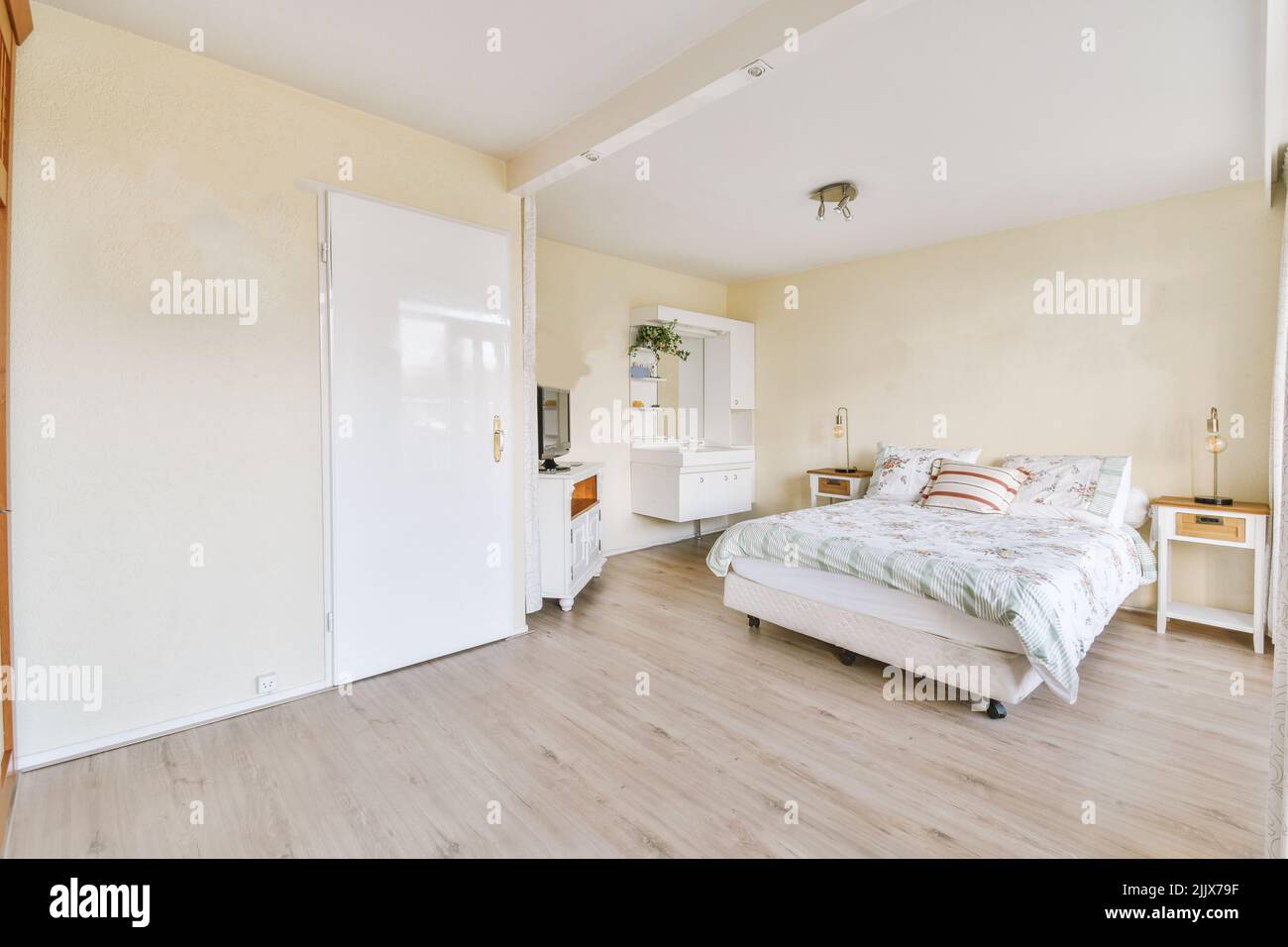 Cómoda cama junto a una ventana luminosa con suelo de madera cerca de una  puerta Fotografía de stock - Alamy