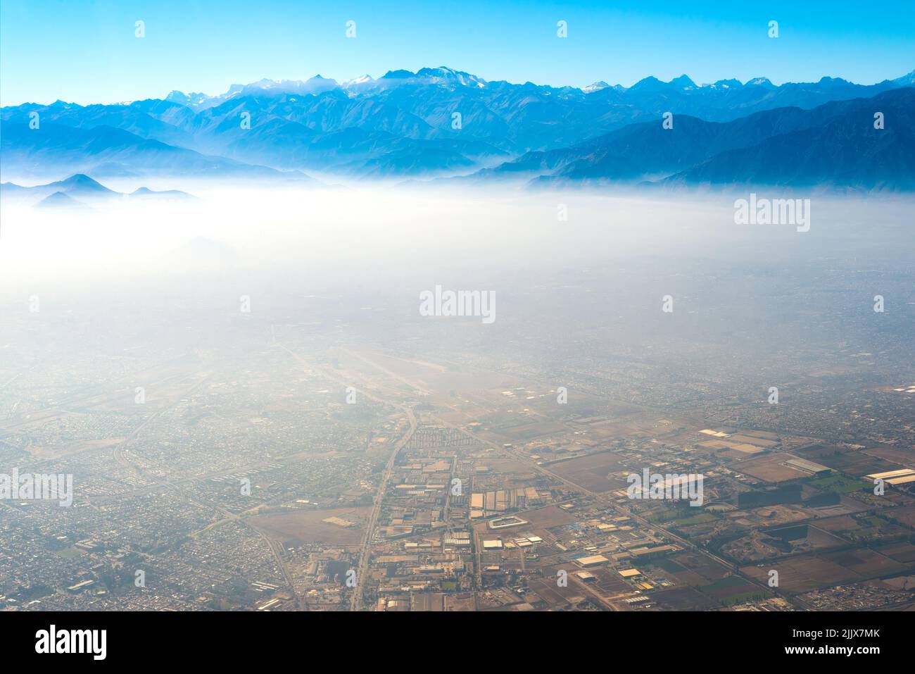 Vista aérea de Santiago de Chile bajo una capa de smog con la cordillera de los Andes en la parte trasera Foto de stock