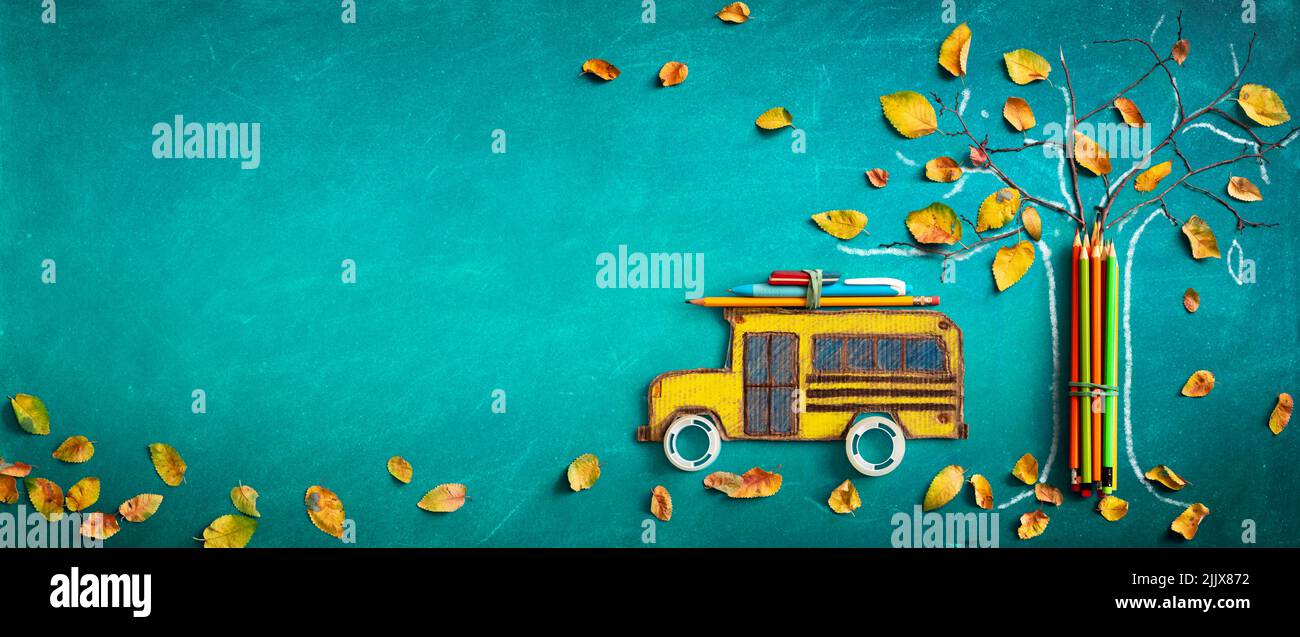 Vuelta a la escuela - Esbozo de árbol de autobuses y lápices con hojas de otoño secas sobre fondo de pizarra Foto de stock