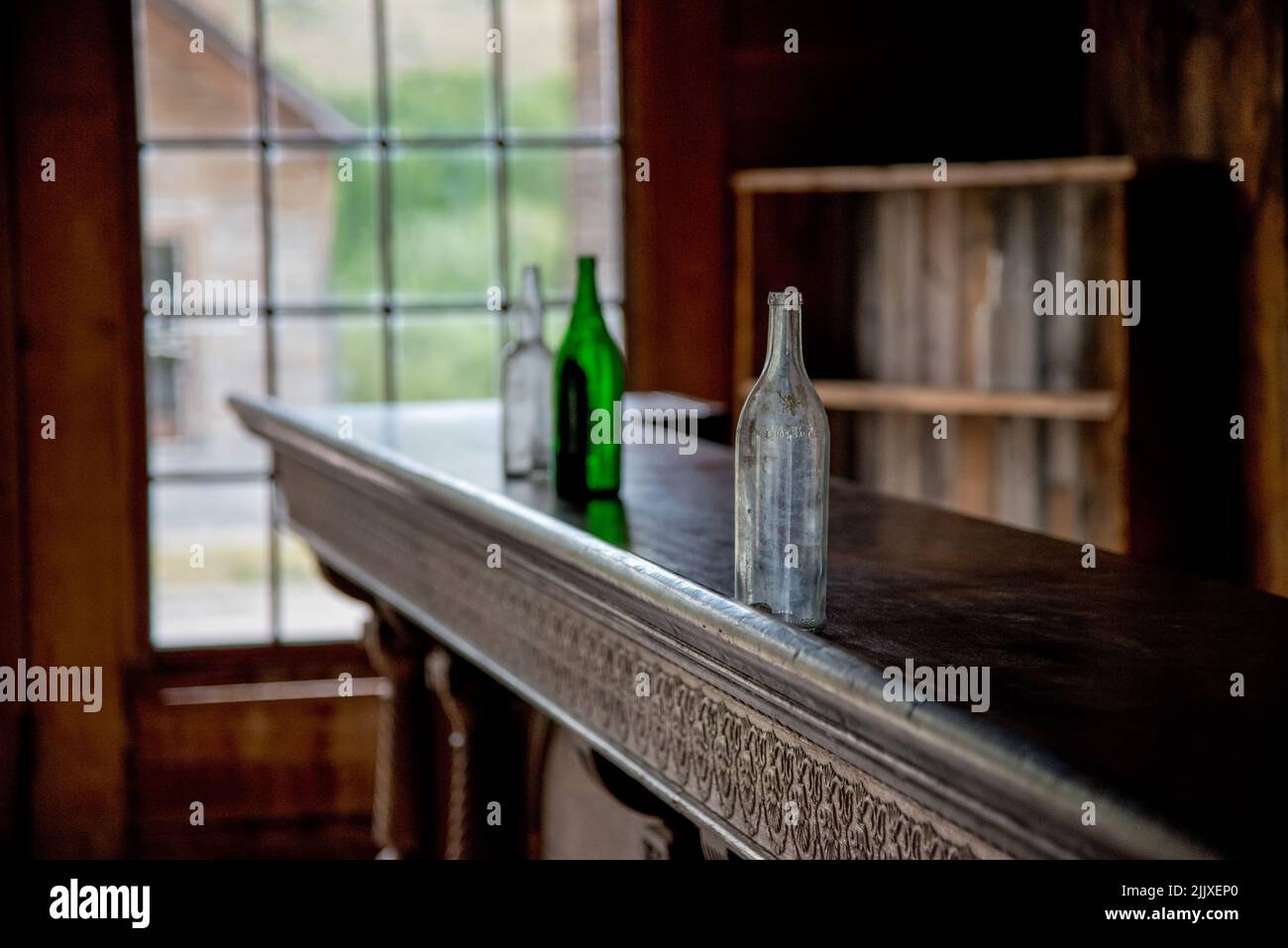 Botellas de whisky vacías en el bar de Skinner's Saloon, un antiguo bar del oeste en la ciudad fantasma minera de Bannack State Park, Montana, Estados Unidos Foto de stock