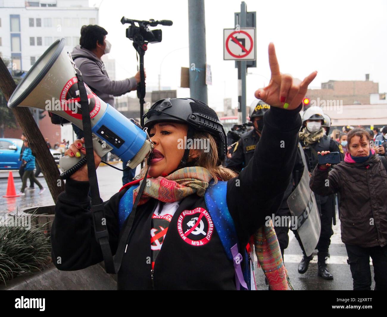 Una mujer del Movimiento Popular Anticomunista tocando el altavoz cuando el día de la independencia del Perú, cientos de personas se reúnen en las calles para protestar contra el presidente Pedro Castillo, acusado de varios actos de corrupción después del primer año de su gobierno. Foto de stock