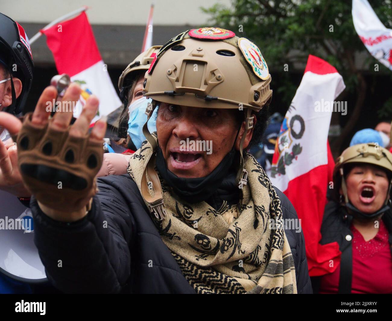 Una mujer afrodescendiente con casco gesticula y grita cuando el día de la independencia del Perú, cientos de personas se reúnen en las calles para protestar contra el presidente Pedro Castillo, acusado de varios actos de corrupción después del primer año de su gobierno. Foto de stock