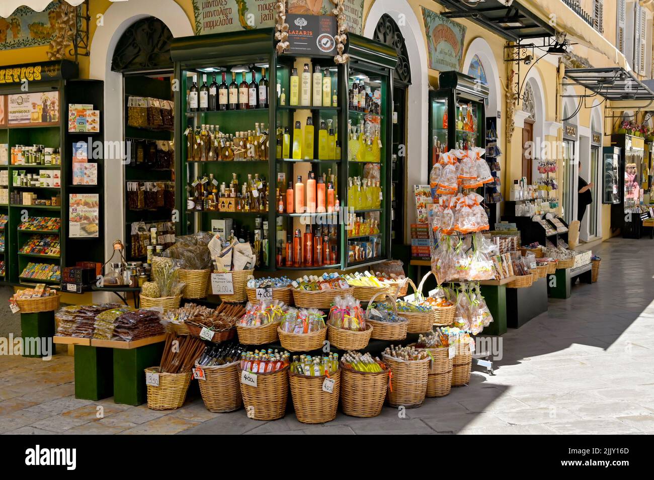 Corfú, Grecia - 2022 de junio: Productos a la venta fuera de una tienda de comida y bebida en una de las calles estrechas de la parte antigua de la ciudad de Corfú Foto de stock