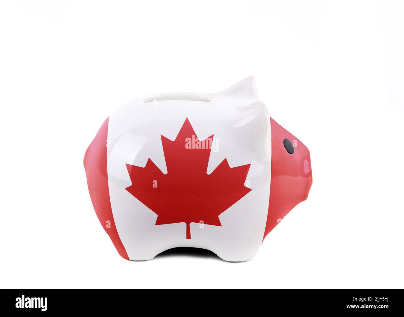 Concepto de ahorro con banco de lechones pintado con bandera canadiense aislado sobre fondo blanco. Foto de stock