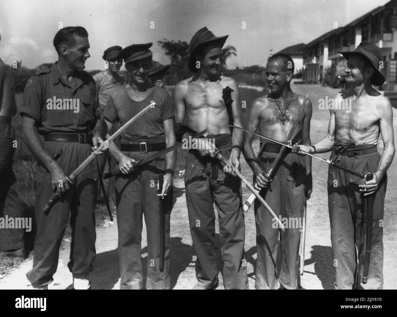 8 División ex-prisioneros de guerra de los japoneses de Tailandia mostrando espadas japonesas que adquirieron de oficiales japoneses. El personal identificado es: SPR. P. Samin (1); DVR. R. Grant (2); Sgt. S.A. Jarvis (3); Pte. R.W. Thiel (4); WO1 J. Unsworth (5). 15 de septiembre de 1945. (Foto de Australian War Memorial Canberra). Foto de stock