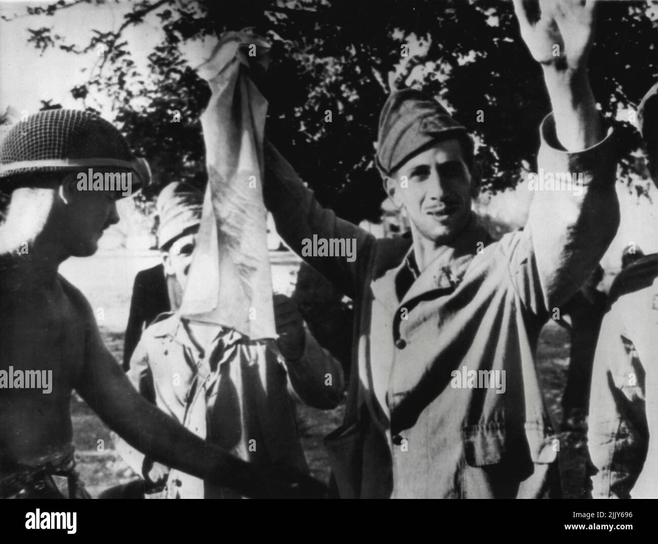 Dando para arriba con una sonrisa -- un soldado italiano se somete alegremente a una búsqueda por un soldado canadiense después de la captura cerca de Rosolini, Sicilia. 31 de julio de 1943. (Foto de AP Wirephoto). Foto de stock