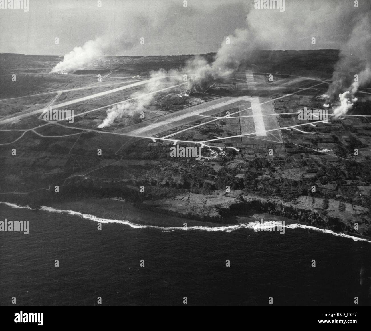 IE Island bombardeada y protegida: Edificios, instalaciones de defensa y aviones en llamas como resultado de los bombardeos y las pruebas realizadas por aviones de transporte de la Tercera Flota del Pacífico bajo el mando del almirante William F. Halsay, Jr., USN, que atacó IE Island el 9 de octubre de 1944. (WLT). La isla IE está justo al oeste de la isla de Okinawa, en el grupo Ryukyu, a unas 850 millas de Tokio. 17 de octubre de 1944. (Foto de la fotografía oficial de la Marina de los Estados Unidos). Foto de stock