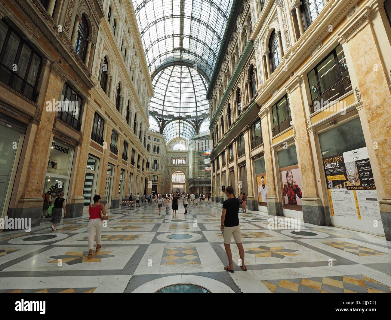 Interior del centro comercial Galleria Umberto 1 en el centro de Nápoles, con gente de compras y hombre tomando fotos. Nápoles, Campania, Italia Foto de stock