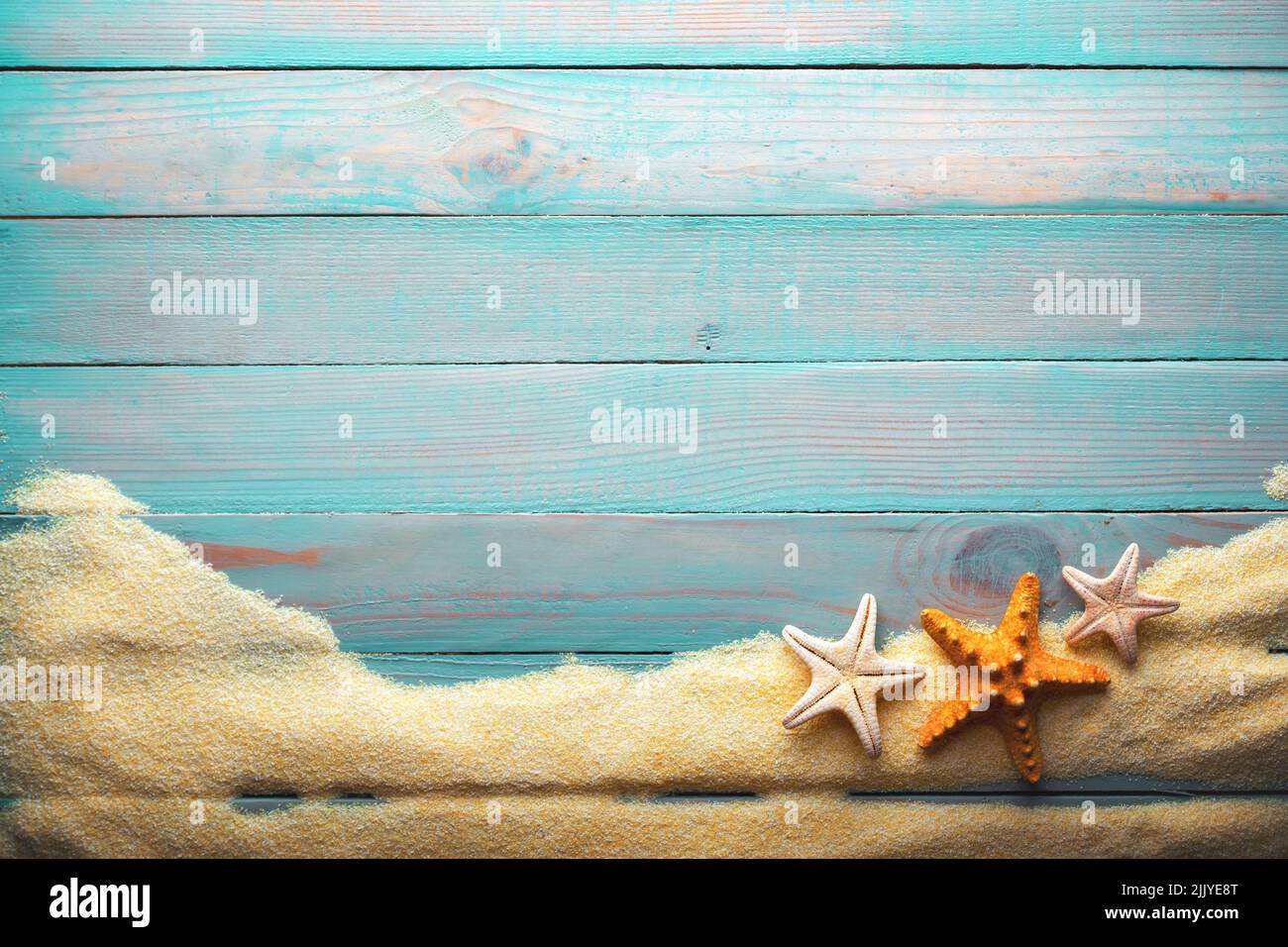 Concepto de vacaciones y tiempo de verano con estrellas de mar sobre una mesa de madera turquesa con arena. Fondo de vacaciones en el mar y el océano Foto de stock