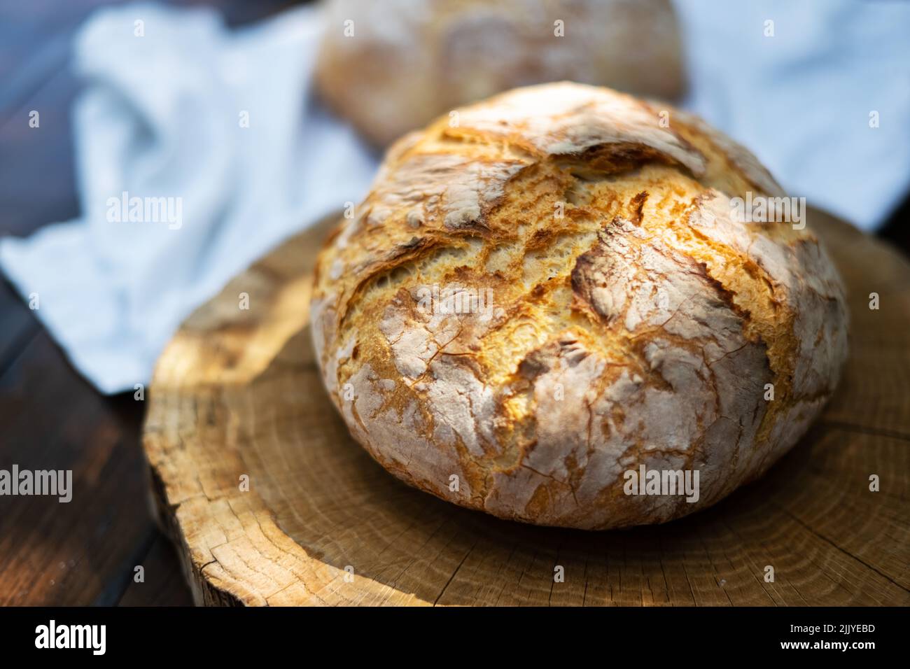 Pan de masa fermentada tradicional con piel de regadura en una mesa rústica de madera. Fotografía de alimentos saludables Foto de stock