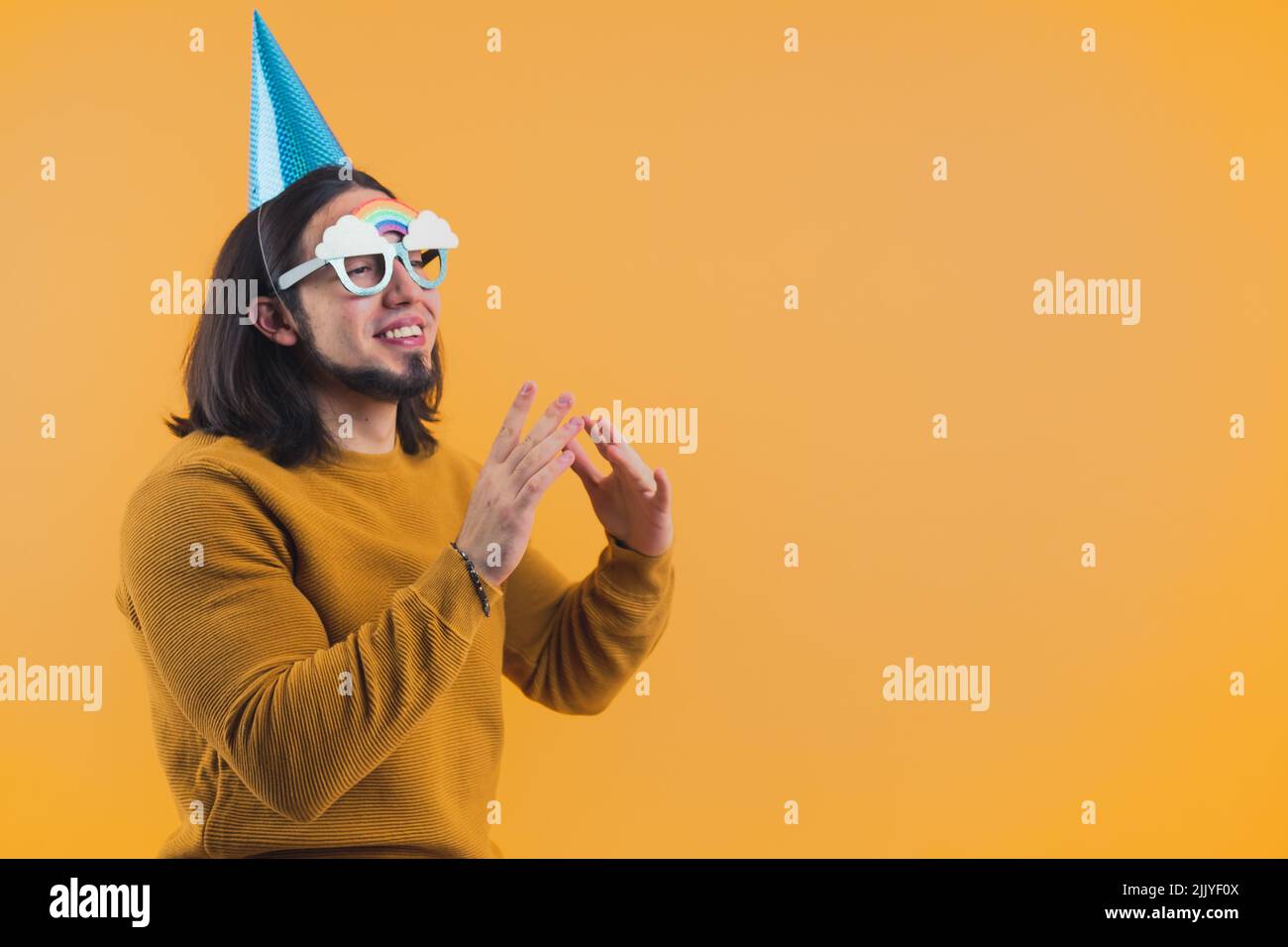 Hombre barbudo feliz usando una gorra de papel en su 30s celebrando su día de cumpleaños. Fotografía de alta calidad Foto de stock