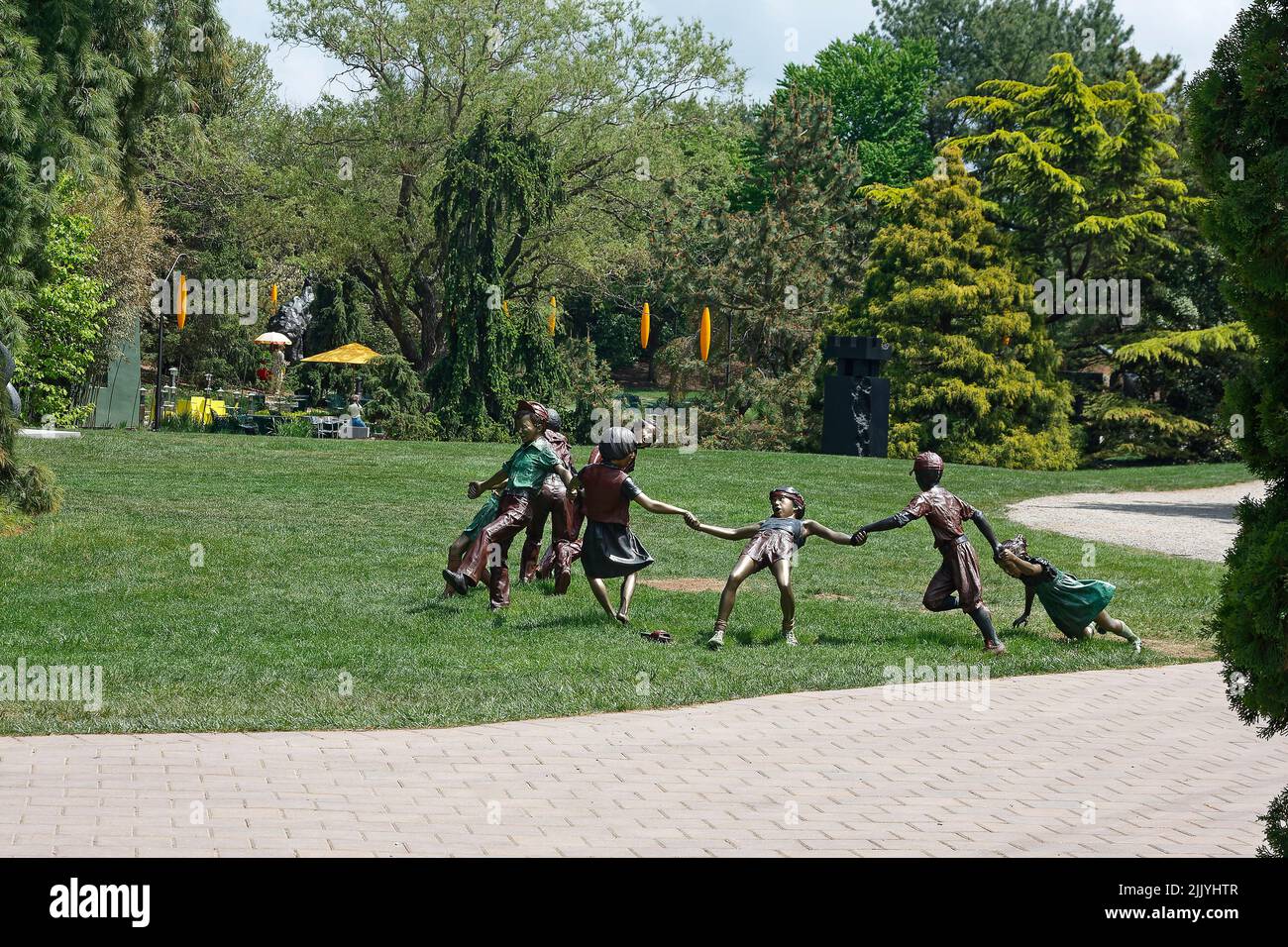 Terrenos para la escultura; niños jugando la escultura, hierba verde, árboles, camino de adoquines, Seward Johnson Center for the Arts, Nueva Jersey; Hamilton; N. Foto de stock