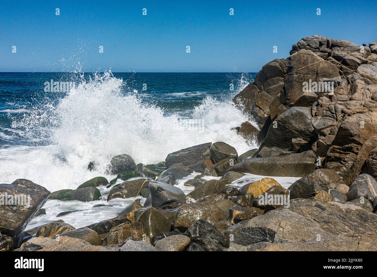Olas rompiendo sobre las rocas en el extremo norte de Playa Sayulita, Sayulita, Nayarit, México. Foto de stock