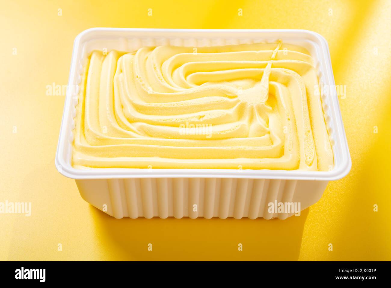 caja de helado con sabor a piña sobre fondo amarillo Foto de stock