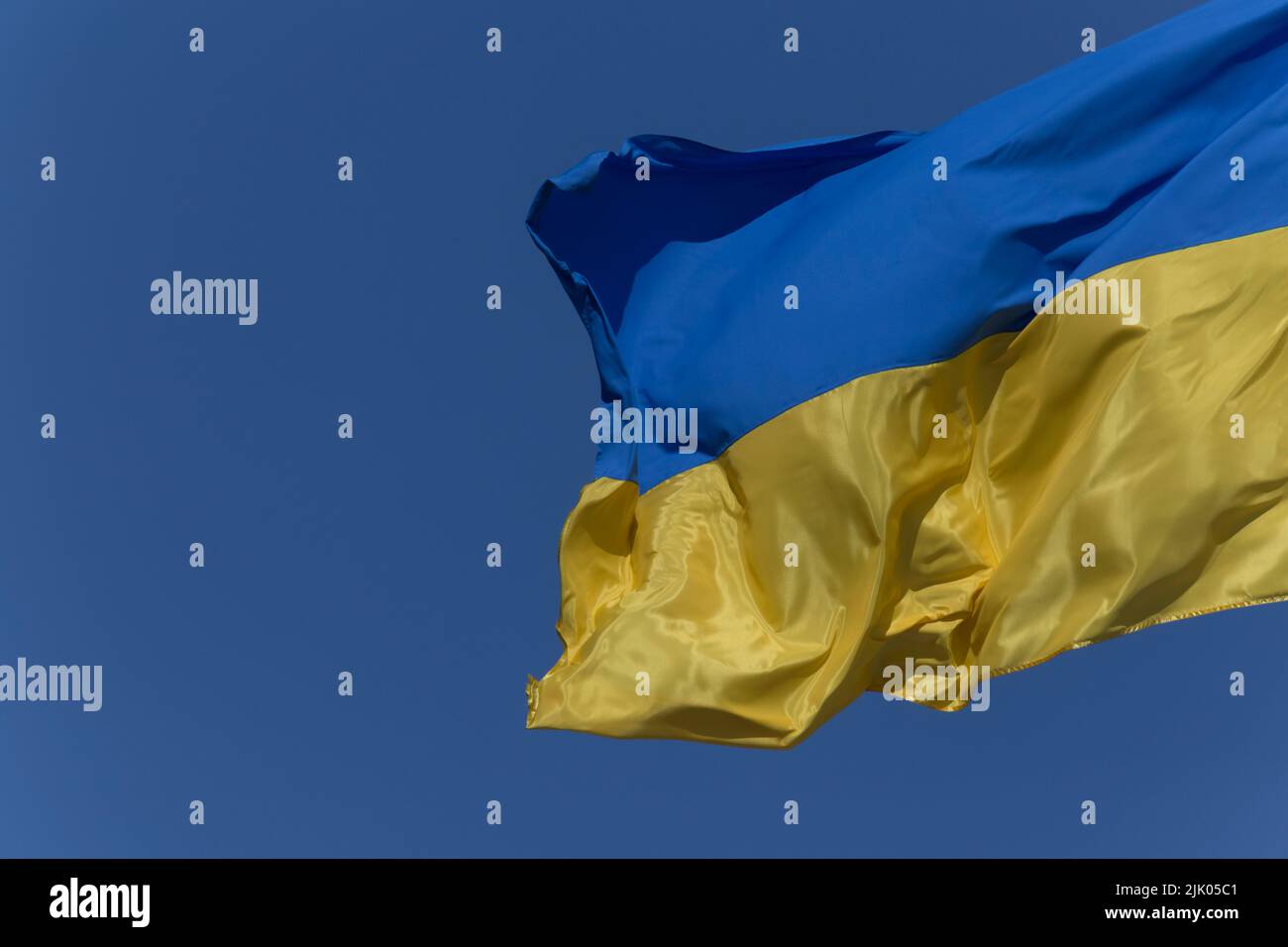 Cerca de la bandera ucraniana ondeada contra el cielo azul Foto de stock