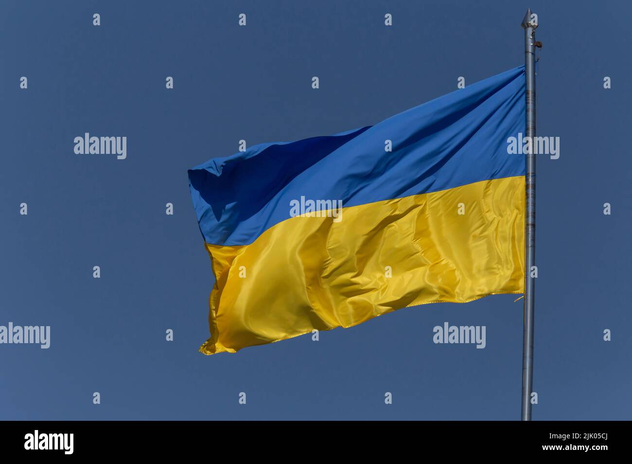 Bandera ucraniana agitada en asta contra el cielo azul Foto de stock