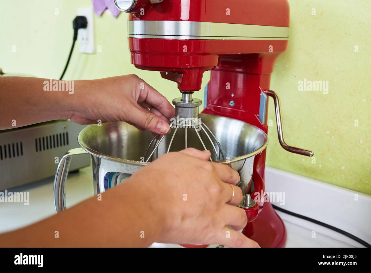 Manos de ama de casa ajustando el batidor en la mesa de amasadora  Fotografía de stock - Alamy