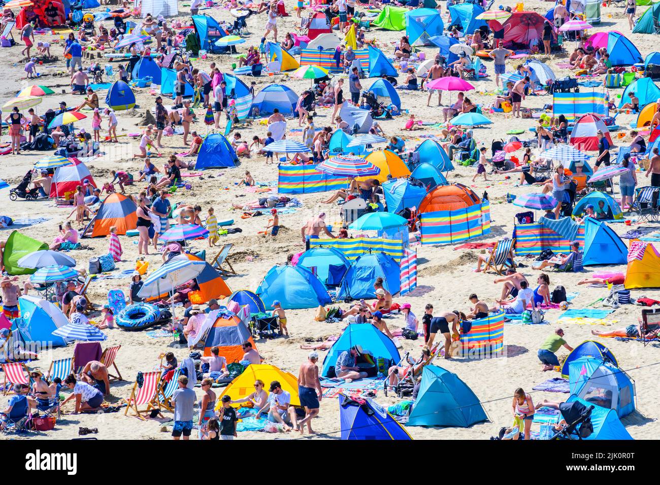 Lyme Regis, Dorset, Reino Unido. 29th de julio de 2022. Clima en el Reino Unido: Las multitudes de turistas y bañistas acuden a la playa abarrotada de la localidad costera de Lyme Regis para disfrutar del sol abrasador. Las familias, los turistas y los que buscan sol se empaparon del precioso clima soleado, ya que hizo un bienvenido regreso a tiempo para el fin de semana. Crédito: Celia McMahon/Alamy Live News Foto de stock